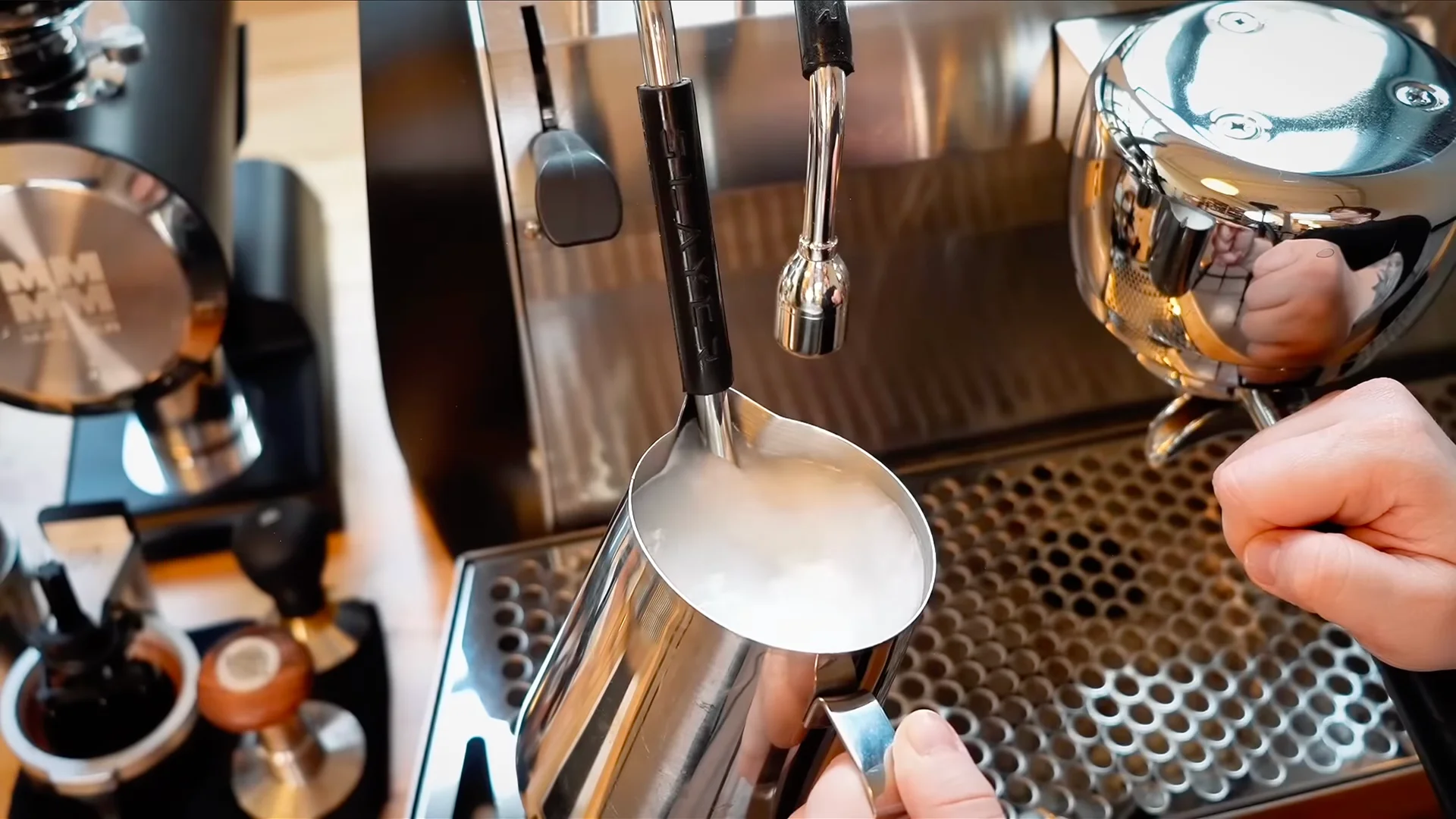 Close-up of an espresso machine steam wand with dried milk residue, showing the need for cleaning during café equipment maintenance